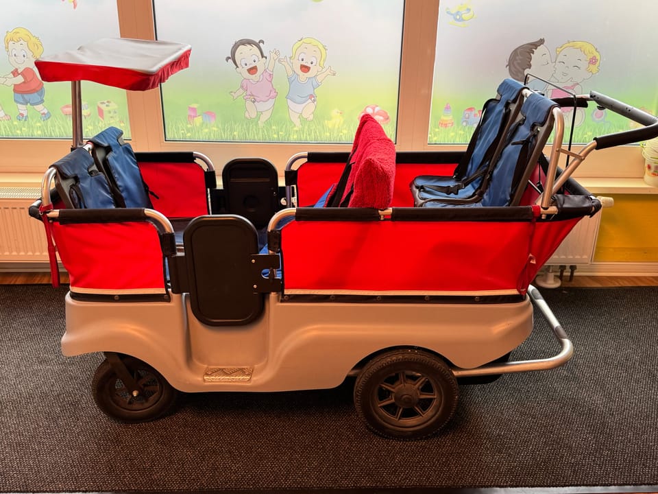 Krippenwagen von der Seite mit Sitzplätzen für mehrere Kinder