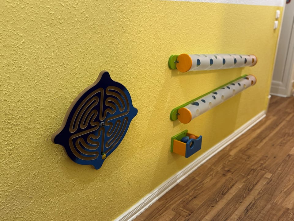 Motorikwand mit Schiebern, Rädern und Zahnrädern zum Drehen und Entdecken
