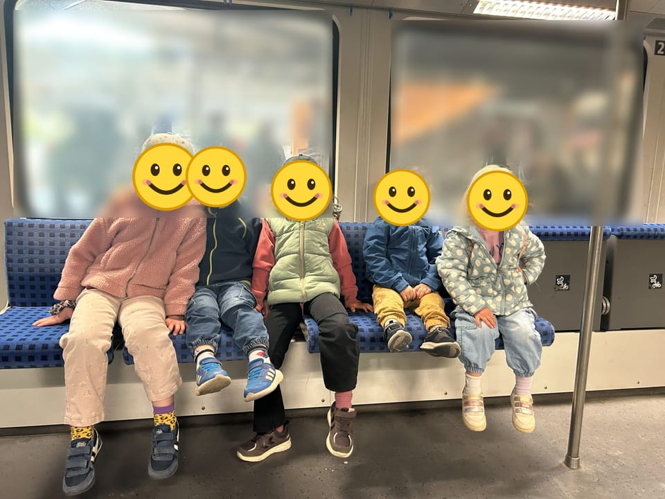 Fünf Kinder sitzen nebeneinander in der S-Bahn